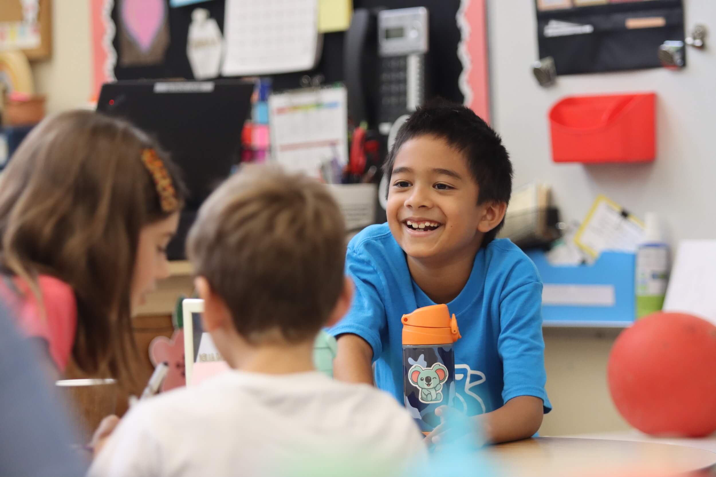 A 2nd grader smiling while working with a group