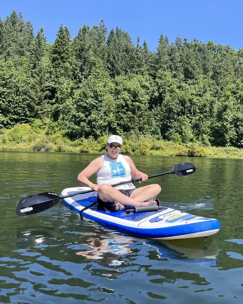 Coach out of the river, sitting and smiling on a paddle boat.