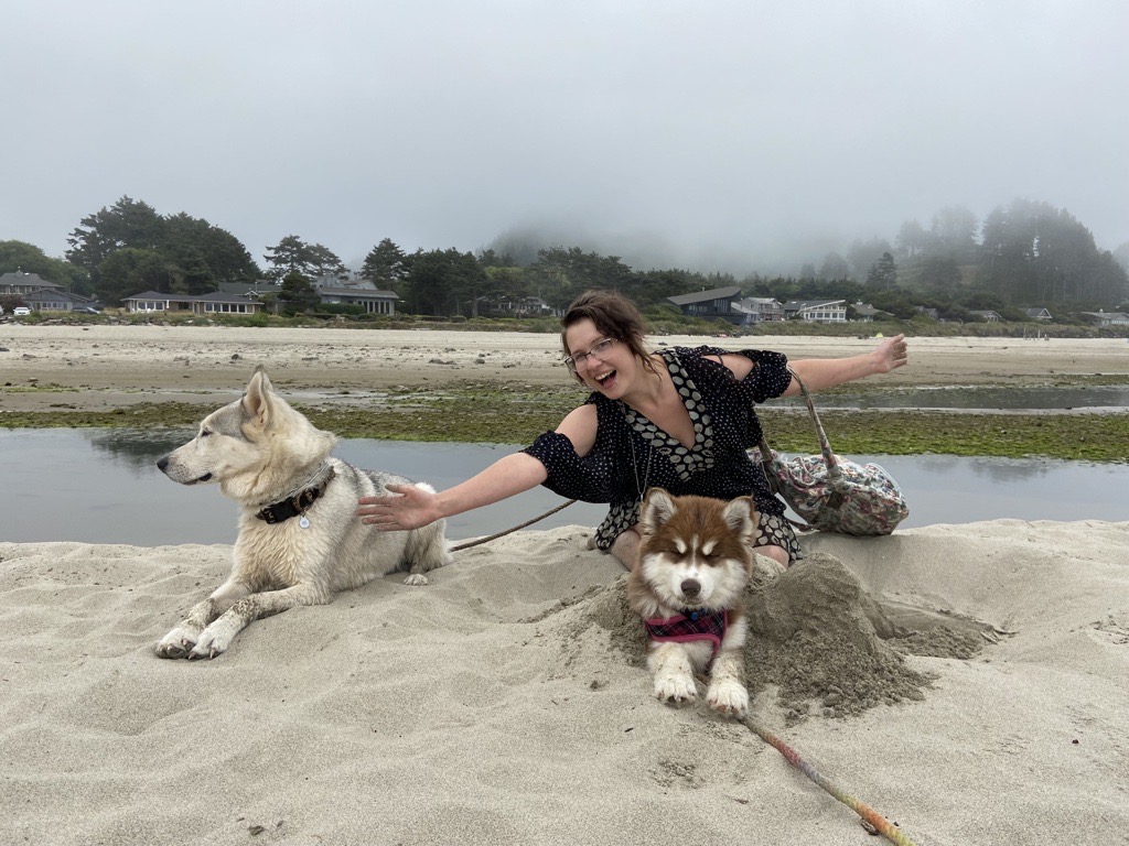 Gwynndolyn outside at the coast with her two dogs