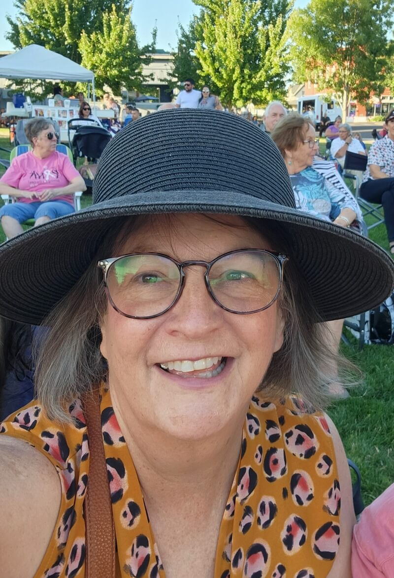 Janice smiling at an outdoor concert.